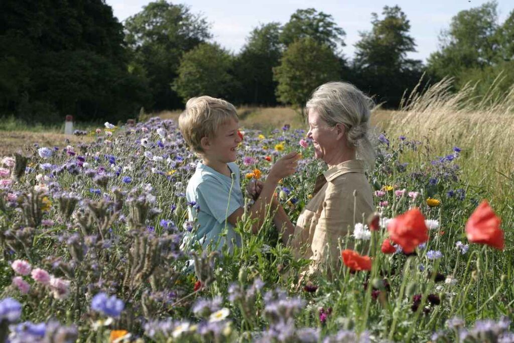 Hvad er mindfulness for børn? Storm og Pia Holgersen nyder mindfulness i naturen omgivet af blomster